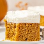 A cream cheese frosted pumpkin bar sitting on a plate.
