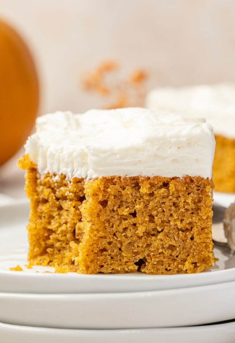 A cream cheese frosted pumpkin bar sitting on a plate.