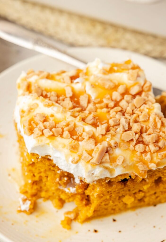 A slice of the pumpkin cake with a fork on a white plate.