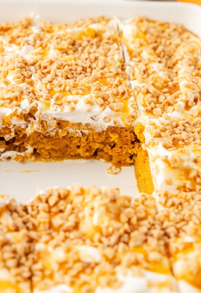 Inside of the pan of pumpkin poke cake, with the middle piece out so you can see the moist cake center.