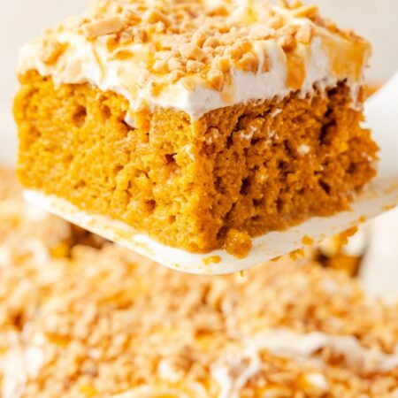 A spatula holding up a slice of the pumpkin poke cake