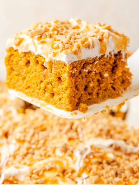 A spatula holding up a slice of the pumpkin poke cake