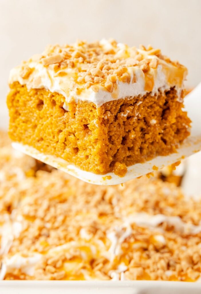 A spatula holding up a slice of the pumpkin poke cake
