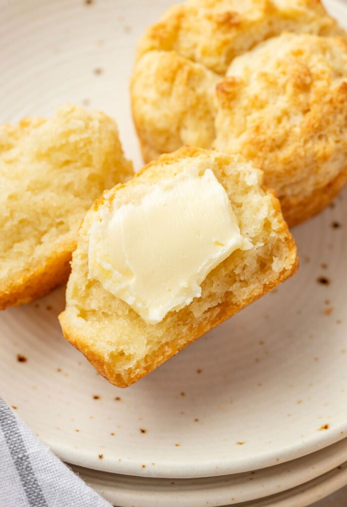 A biscuit cut in half with butter on it