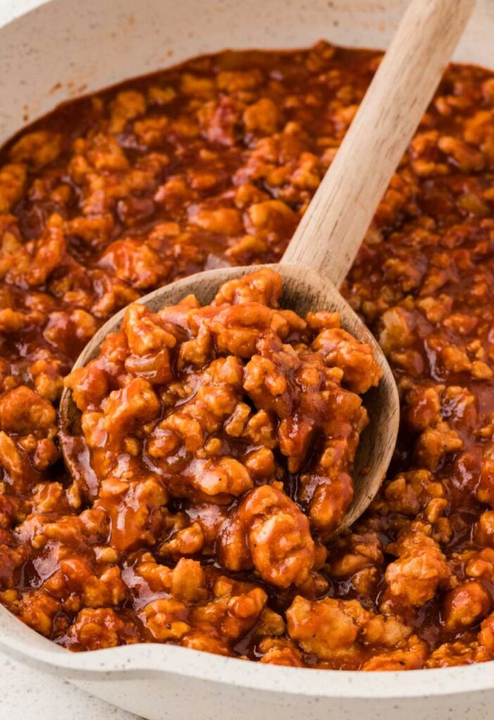 a wood spoon with some of the ground chicken sloppy mixture on it