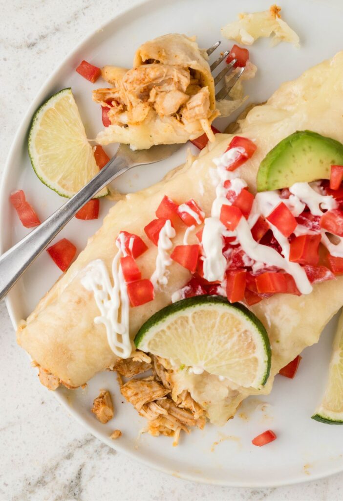 A plate of honey lime enchiladas with a fork