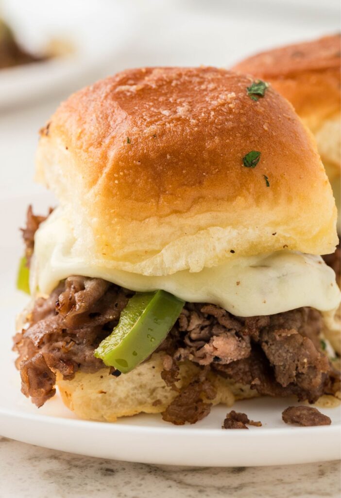 A philly cheesesteak sliders on a white plate
