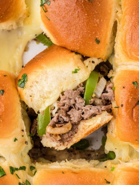 philly cheesesteak sliders, baked and ready to serve with one sideways to see the middle