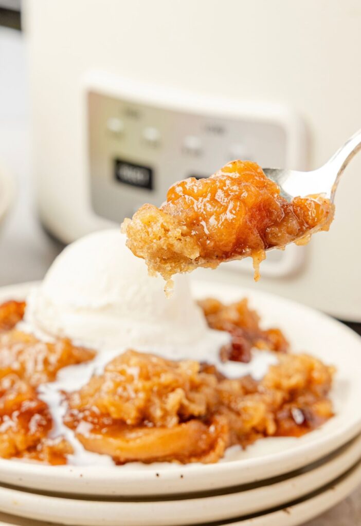 A spoon with some apple crumble on it.