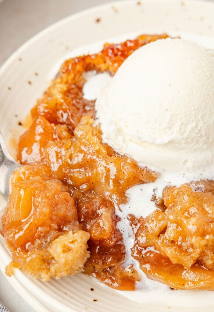 A serving of apple crumble topped with vanilla ice cream