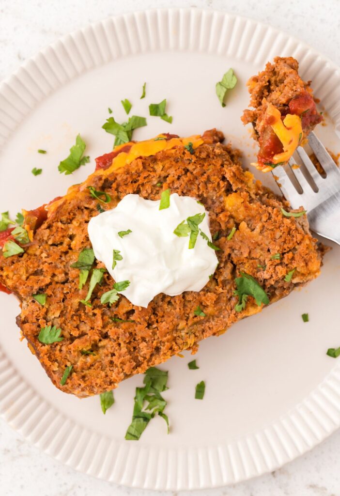 slice of meatloaf on a white plate with a fork